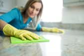 woman cleaning a stone countertop