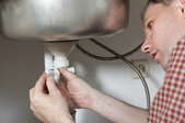 A man installing kitchen sink plumbing.