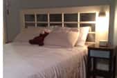 Bed with white bedspread and mirrored headboard.