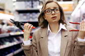 confused woman with clippers and pliers in hardware store