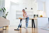 Woman steam mopping a living room floor
