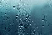 A close-up image of moisture droplets on a glass surface.
