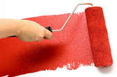 A paint roller applying a red, semi-gloss paint to a white surface.