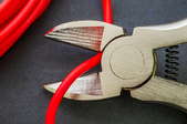 wire cutters cutting a red wire