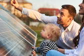 parents and young child with solar panels