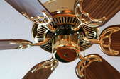 a brown and brass ceiling fan on a white ceiling
