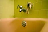 The shower faucet and diverter face plate in a bathroom with green tile.