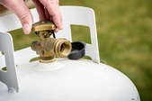 hand turning the valve on a propane tank