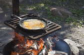 skillet cooking on a grate over a fire