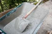 cement waiting to be mixed by a shovel in wheelbarrow