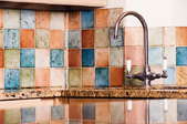 A kitchen backsplash made of colorful ceramic tiles.