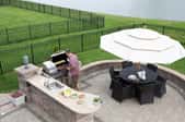 An aerial view of an outdoor kitchen with a table and BBQ. 