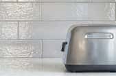White tile backsplash with toaster in front