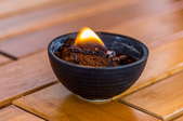burning coffee grounds in a dish on a wooden table