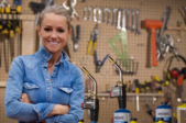 HGTV Star Nicole Curtis standing in a workshop with Bernzomatic blow torches. 
