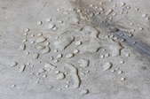 A concrete floor with water droplets on it.