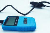A blue card code reader with its plug