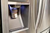 A water and ice dispenser in the door of a stainless steel refrigerator.