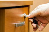hand turning a key in a drawer lock