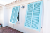 White house with two light blue Bahama shutters