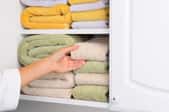 A linen closet with folded towels.