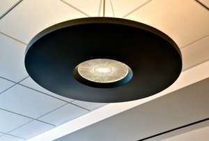 A circular light hanging from a suspended ceiling.