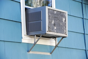 Air condition in the window of a blue house.