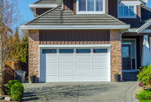 Front of a house with white garage door and brick façade.