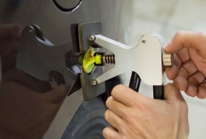 hands using car dent repair device to fix car body