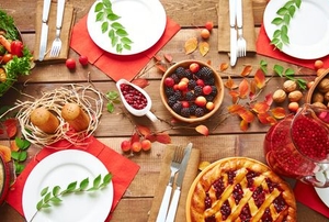 table set for thanksgiving with turkey, berries, pie, and nuts