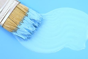 paintbrush applying lighter paint to darker background