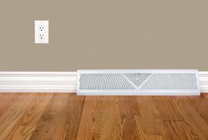 A baseboard heater on a wood floor.