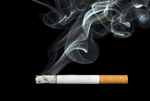A Cigarette with smoke on a black background.