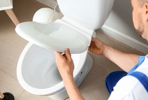 worker installing new toilet