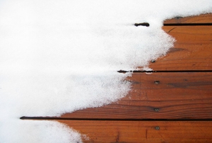 Snow on a wood deck.