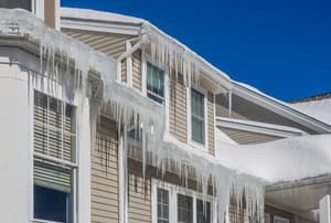 A house with icicles hanging off the roof. 