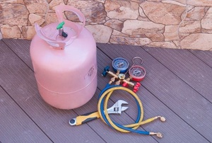 A Freon tank and gauges lay out on a deck.