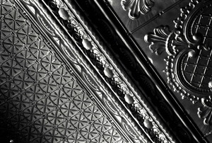 A close-up of stamped ceiling tiles in black and white.