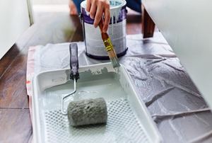 paint roller in a tray with light colored paint