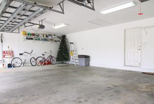 A garage with concrete floors and a few items stored to one side.