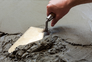 A person smoothing concrete.
