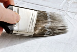 A paint brush applying primer.