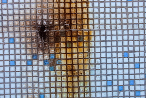 Extensive rust stains on a surface of small tiles.
