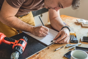 man planning home improvement at a workshop table