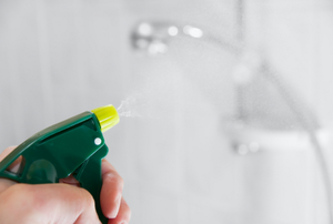 the nozzle of a spray bottle aimed at a shower