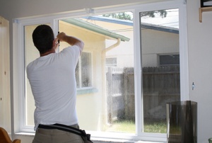 A man installs a window film.