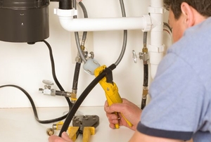 Person making repair to plumbing