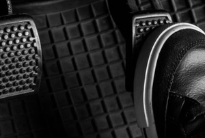 foot in black shoe on car pedal