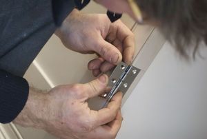 person installing door hinges