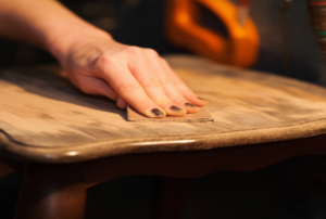 A woman works on laminate wood furniture.